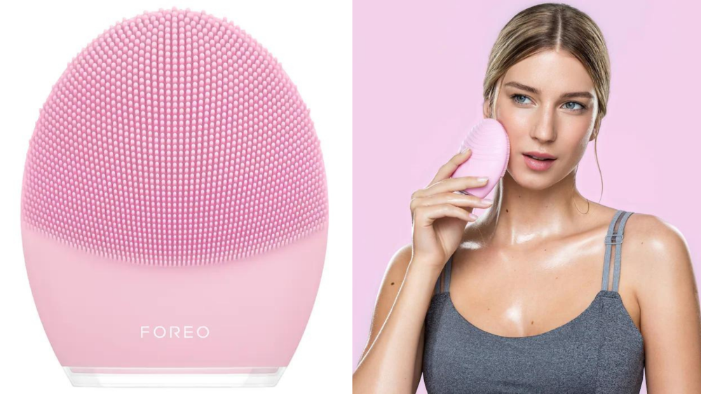 A woman uses a Foreo device on her face.