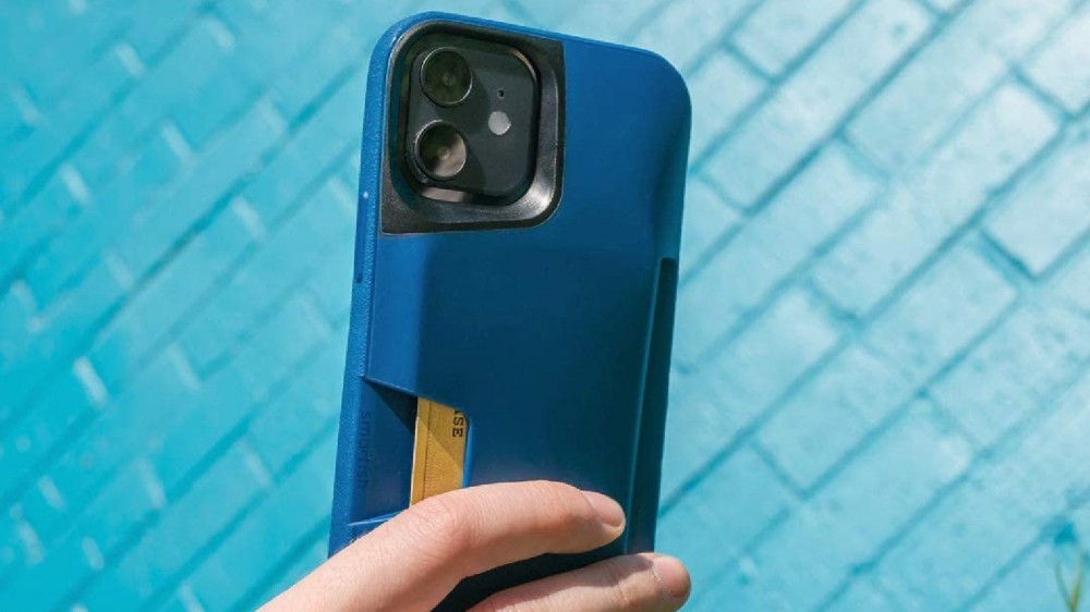 A hand holds an iPhone that's in a blue wallet case.