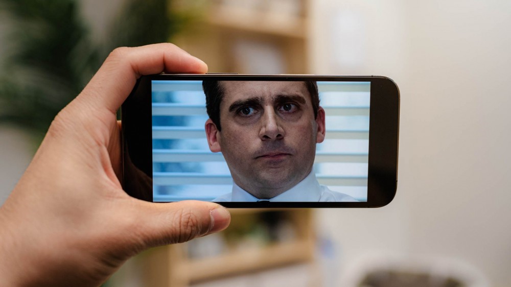 Person watching The Office on an iPhone